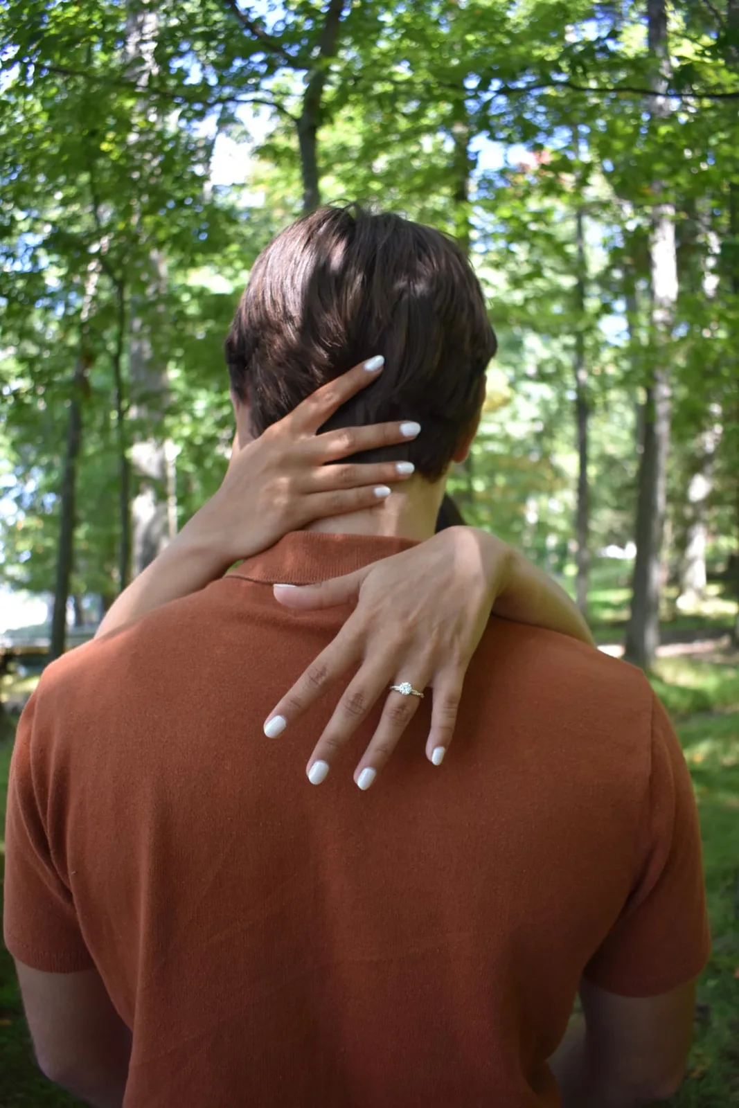 Emily embracing Thomas and showing her engagement ring.