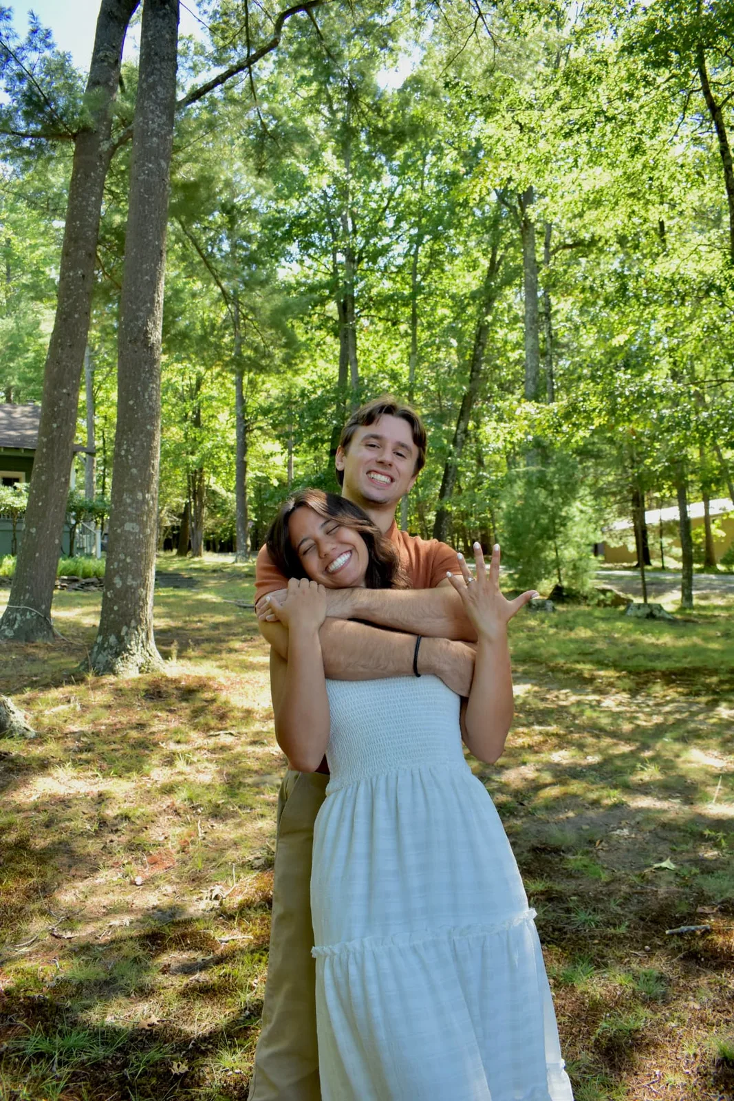 Emily and Thomas celebrating their engagement among the trees.