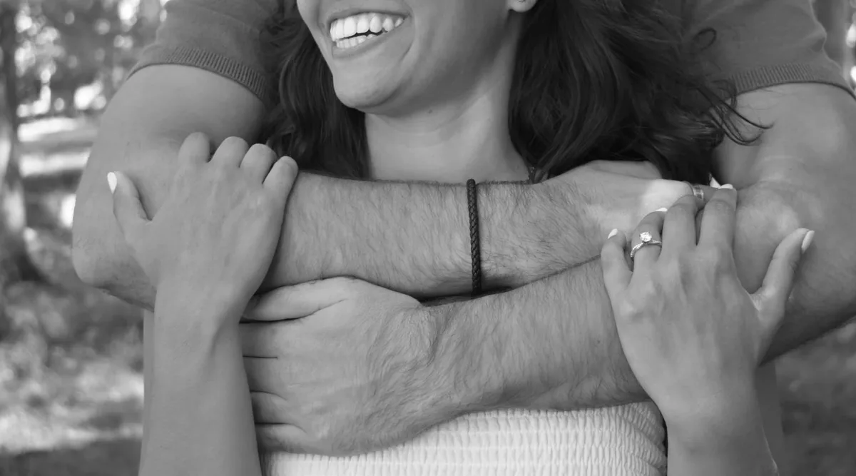 A joyful black-and-white portrait of Emily and Thomas embracing.