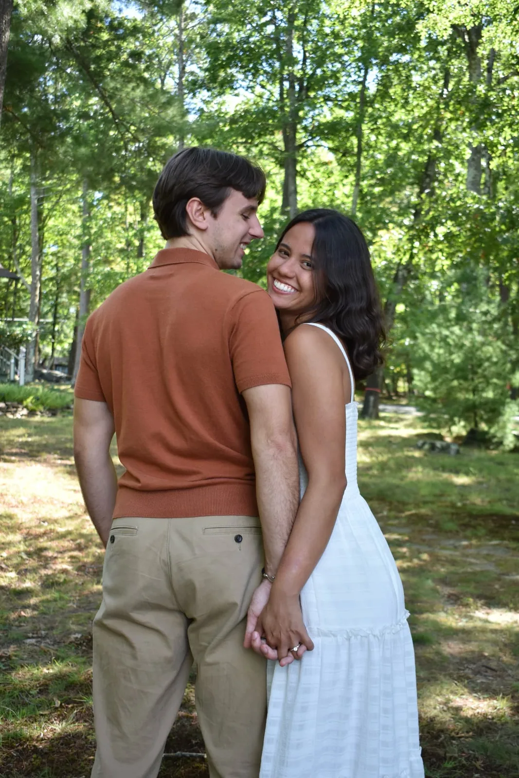 Emily and Thomas holding hands and smiling together in the gardens.