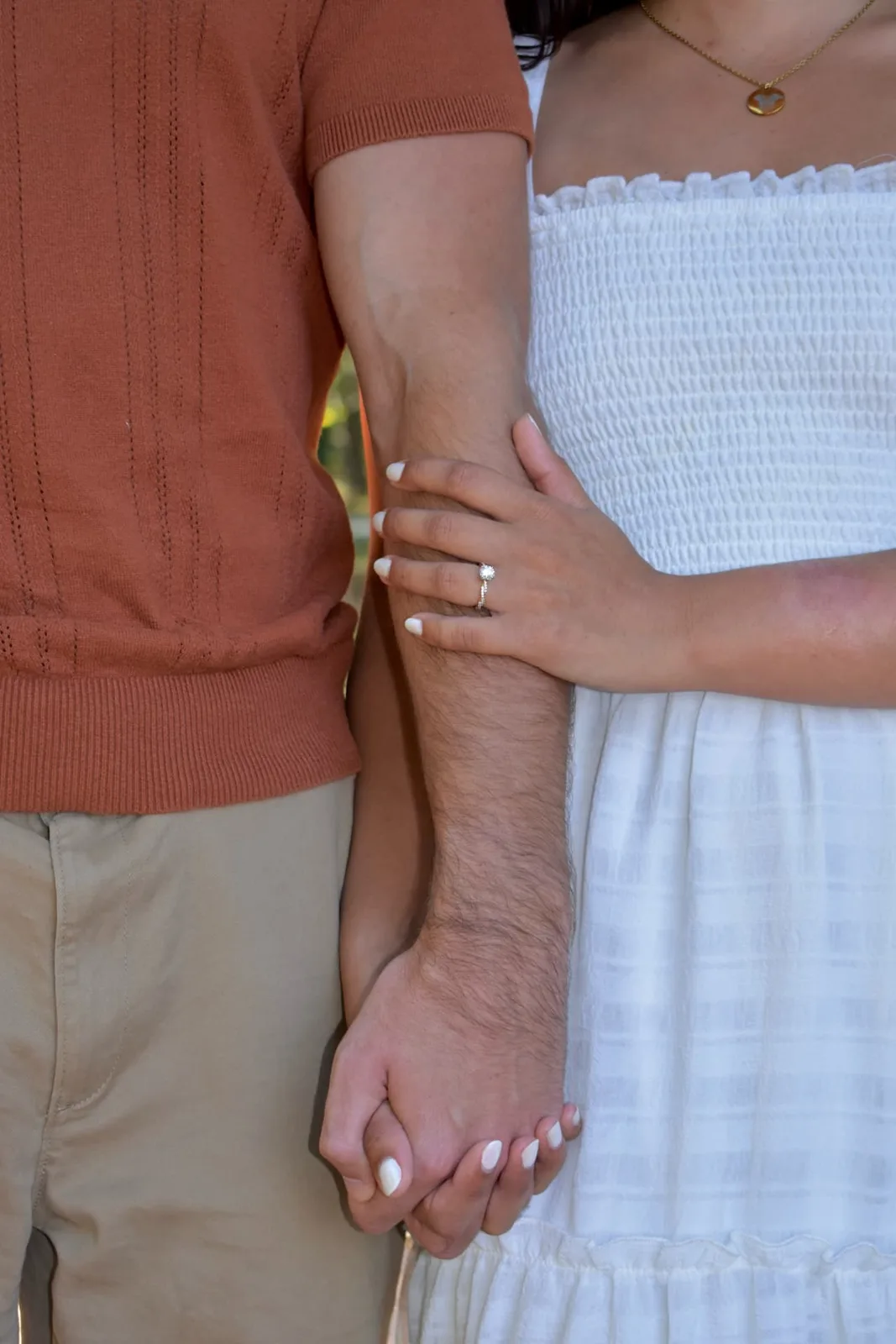 Emily and Thomas holding hands with her engagement ring in view.
